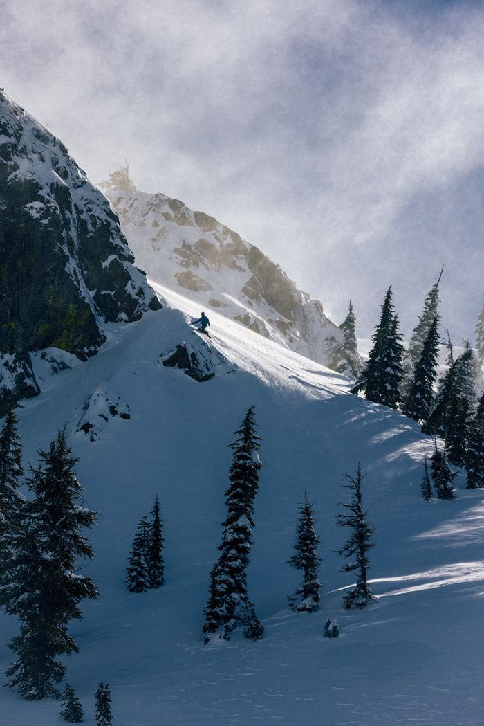 Photo by Neil DaCosta of a snowboarder about to drop into some soft snow at high elevation near Tahoe.